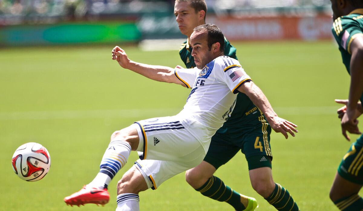 Galaxy midfielder Landon Donovan volleys a pass in front of Timbers midfielder Will Johnson during a game earlier this season in Portland, Ore.