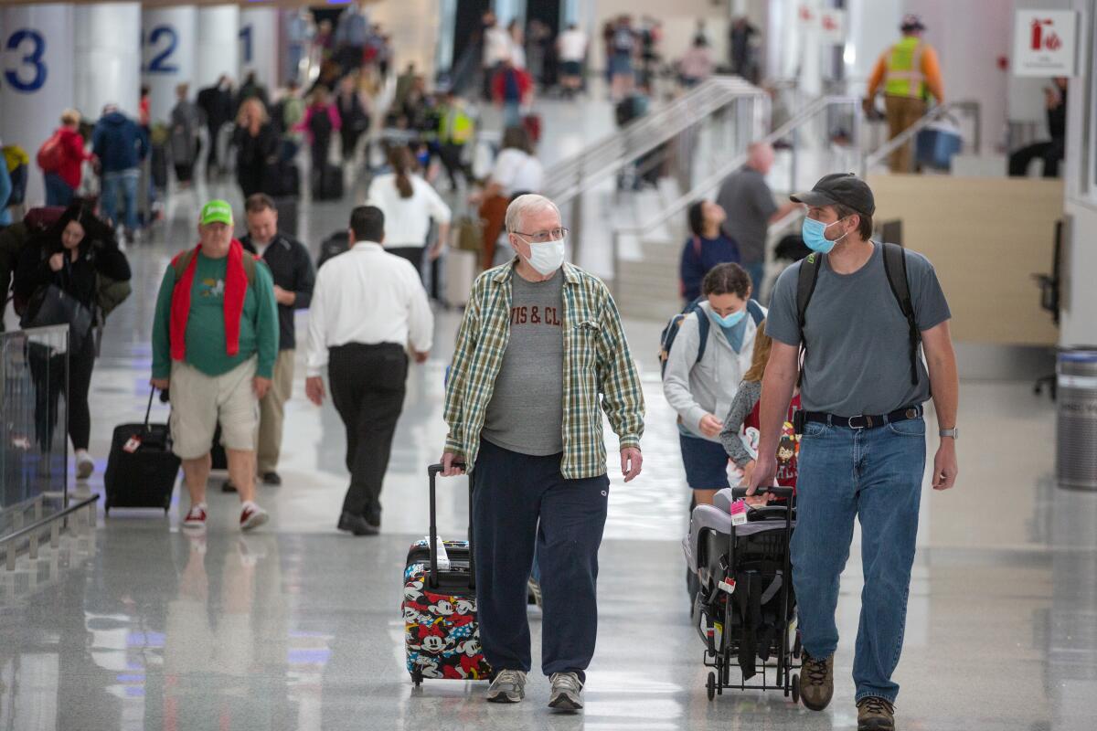 Los Angeles International Airport passengers walk through the airport with luggage.