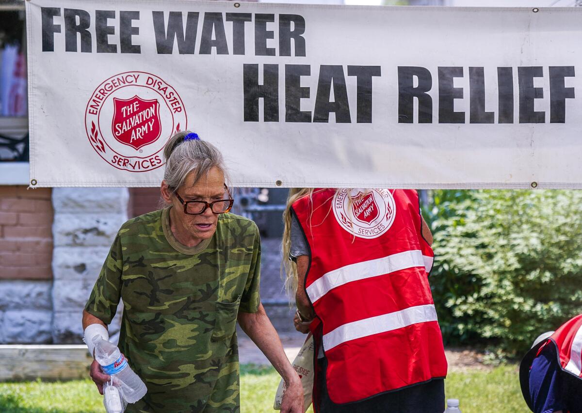 A pedestrian holds a bottle of cold water at a Salvation Army hydration station in Phoenix on June 15. 
