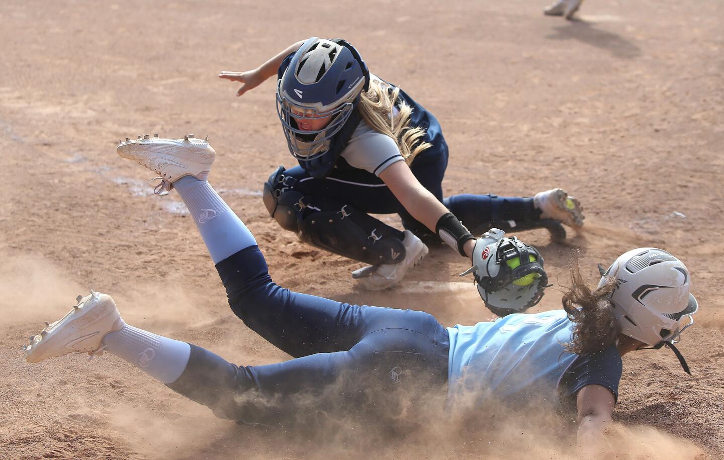 Newport Harbor catcher Kendall Kelly just misses the tag on Corona del Mar's Sydney Walls who scores during Battle of the Bay, Wave League softball game on Friday,