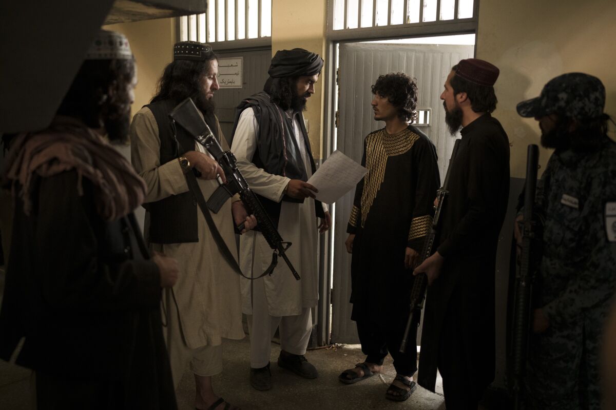 Taliban fighters talk to a detainee before transferring him to a court in Kabul, Afghanistan, Sunday, Sept. 19, 2021. The Taliban are shifting from being warriors to an urban police force. (AP Photo/Felipe Dana)