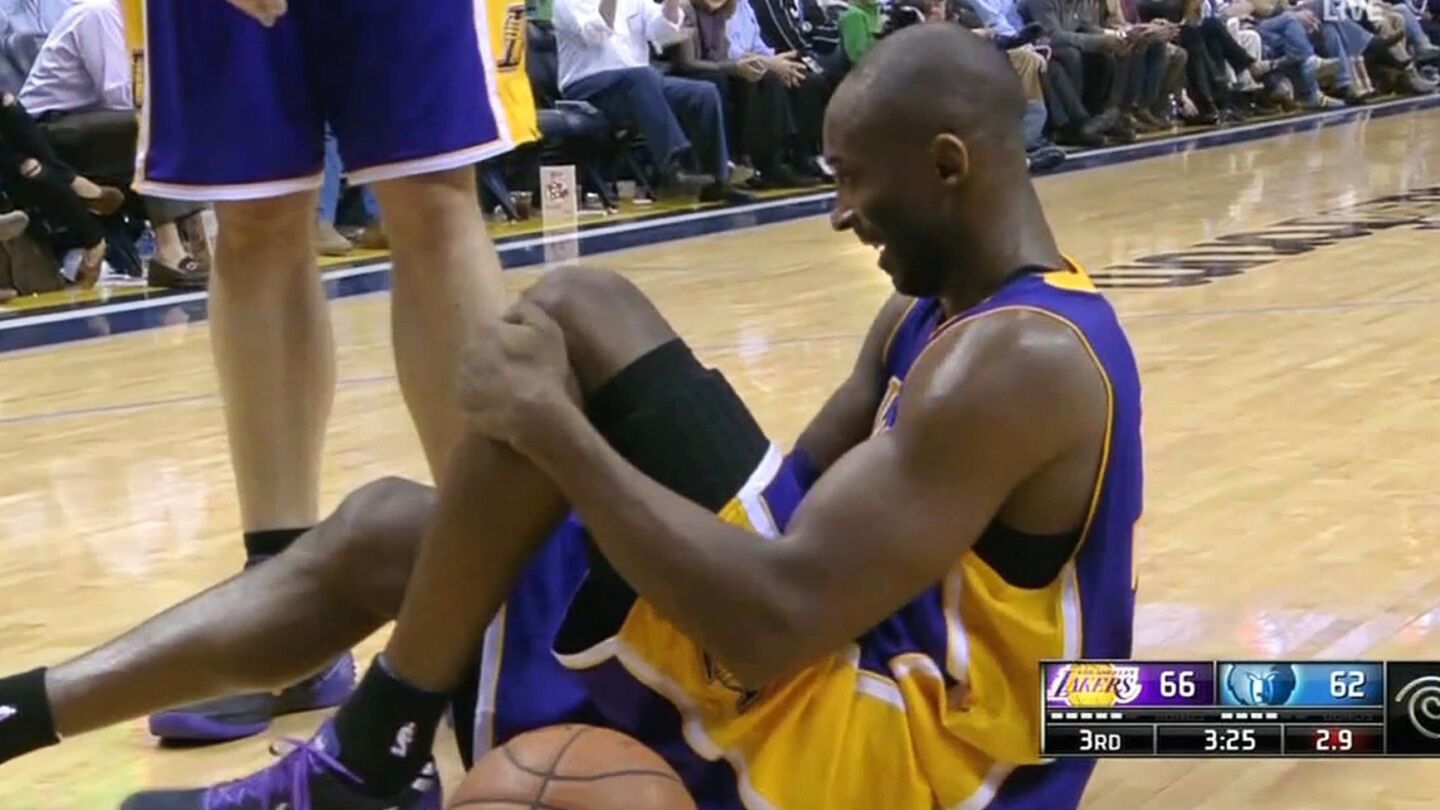 Kobe Bryant holds his left knee after a play against Memphis Grizzlies at the FedExForum in Memphis, Tenn., on Dec. 17, 2013. Bryant suffered a fracture on his tibia and missed the remainder of the 2012-13 season.