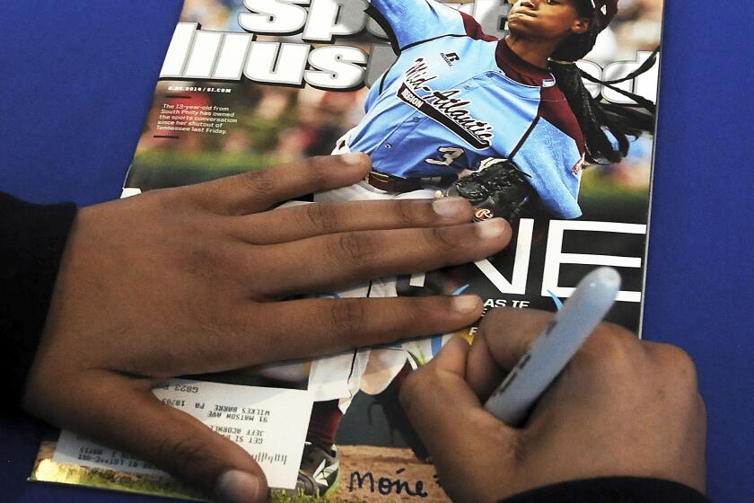 FILE - In this Saturday, Feb. 27, 2016 file photo, Mo'ne Davis, 14, of Philadelphia, signs an autograph for a fan on the cover of Sports Illustrated magazine at PNC Field in Moosic, Pa. Little-known media company Maven, Sports Illustrated?s new manager, says the sports magazine is cutting more than 40 jobs out of a staff of 150. Maven spokesman Greg Witter says it will add 200 contractors to cover college and professional sports teams for Sports Illustrated. Maven struck a licensing deal to operate Sports Illustrated with the magazine?s new owner, branding company Authentic Brands Group, in June. (Butch Comegys/The Times-Tribune via AP, File)