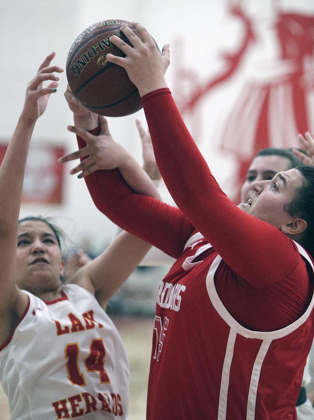 Burroughs' Sydney Martin pulls down a rebound against Whittier Christian's Aidan Sherfey in the CIF Southern Section Division II-A girls' basketball quarterfinal at Whittier Christian High School in La Habra on Wednesday, February 19, 2020. Burroughs won the game 41-39, a game that was hard fought until the last points were scored