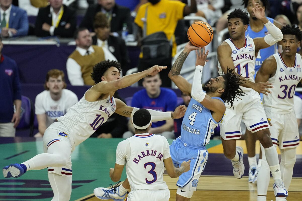 North Carolina guard R.J. Davis (4) shoots against Kansas forward Jalen Wilson (10) during the first half of a college basketball game in the finals of the Men's Final Four NCAA tournament, Monday, April 4, 2022, in New Orleans. (AP Photo/Gerald Herbert)