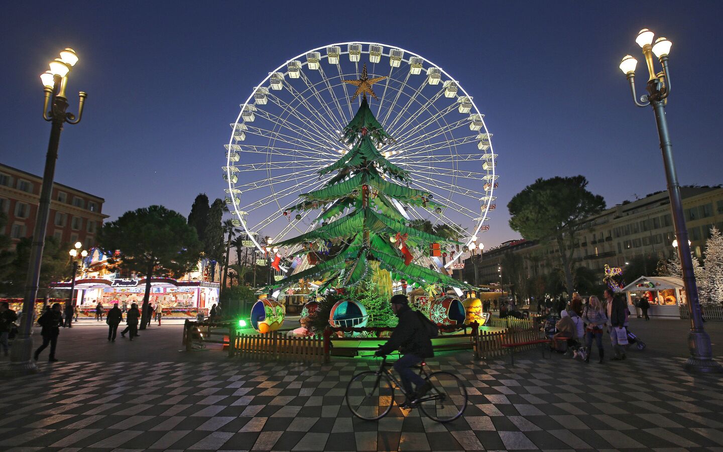 Nearby in the city center, a giant Christmas tree is on display in front of a popular Ferris wheel, giving it a halo effect.