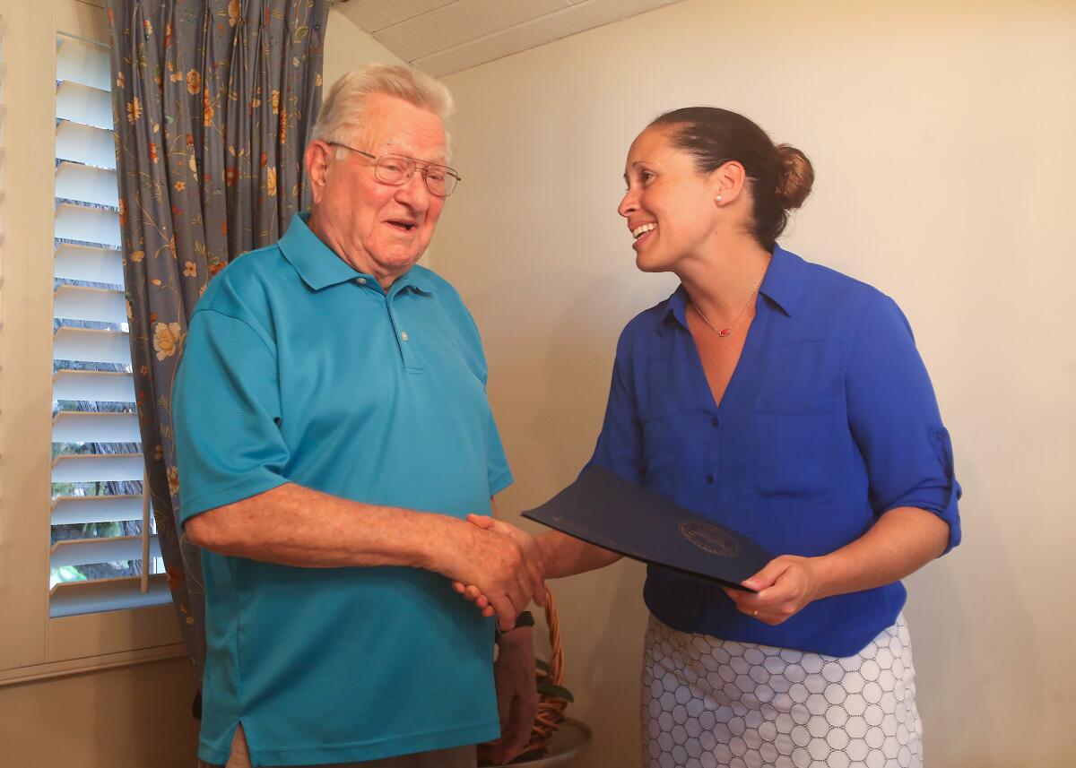 Costa Mesa Councilwoman Andrea Marr congratulates Jerry Florey for his work on the Apollo missions before giving a certificate of appreciation during a visit to his home.