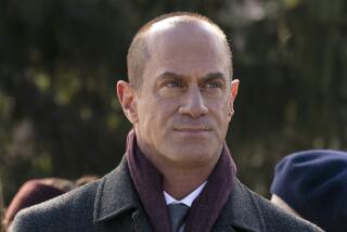 Christopher Meloni in a purple scarf and gray pea coat