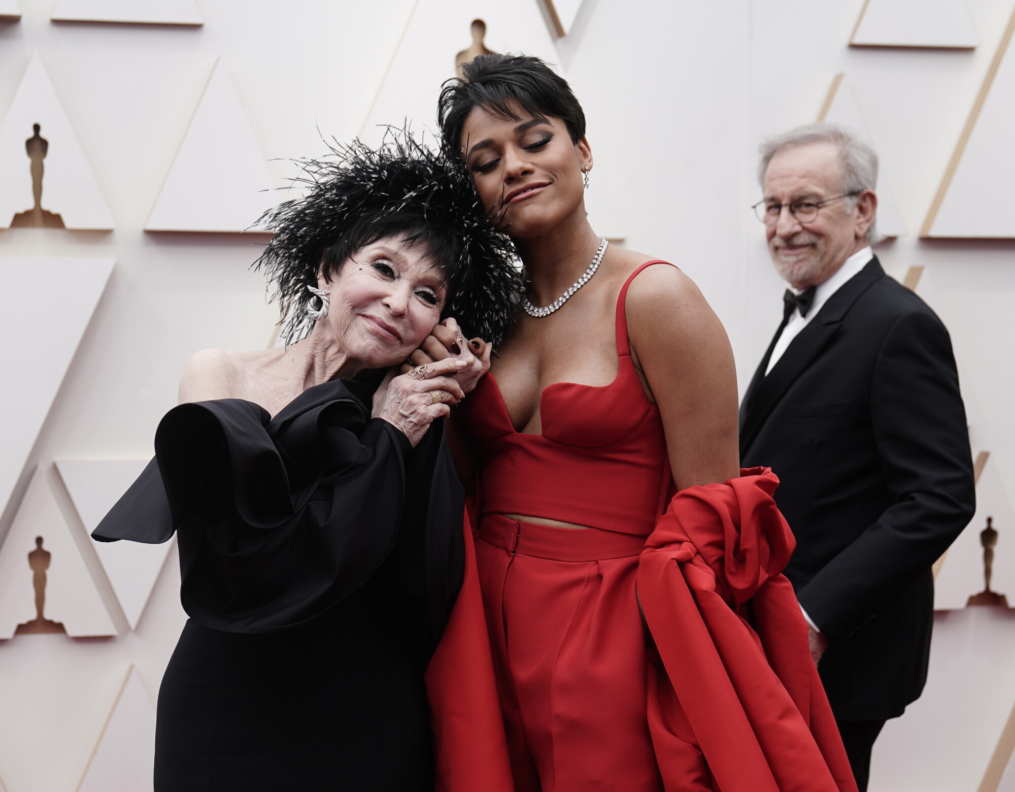 Rita Moreno, izquierda, y Ariana DeBose llegan a los Oscar. Al fondo mira Steven Spielberg.