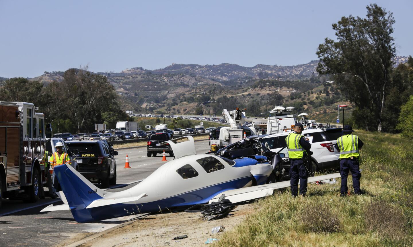 CHP investigators gather at at the site of a small plane that slammed into a car on Interstate 15 in northern San Diego County on Saturday.