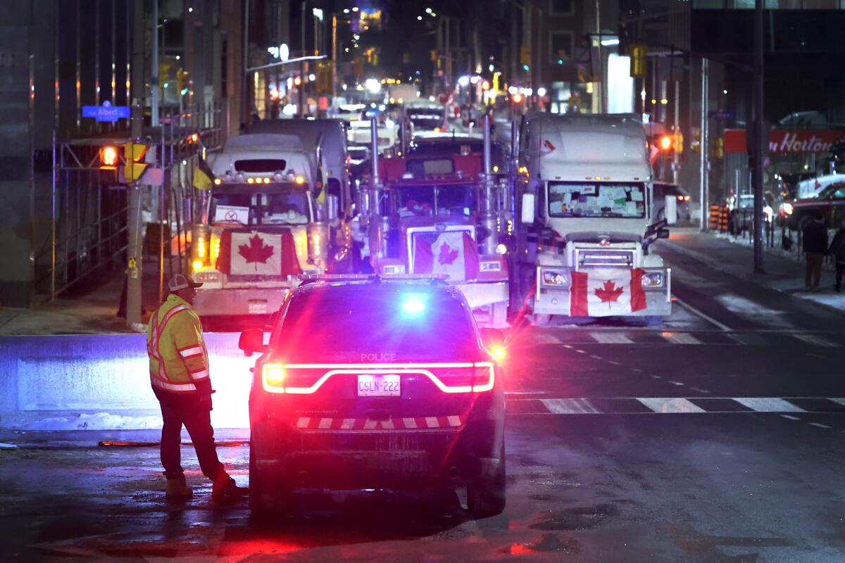 A police vehicle blocks a downtown street to prevent trucks from joining a blockade