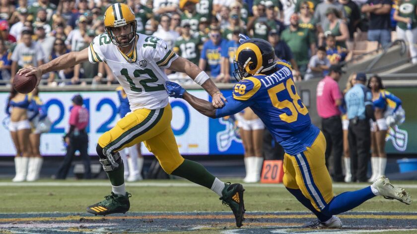 Rams' Cory Littleton, right, sacks Packers' Aaron Rodgers in the first quarter at the Coliseum on Oct. 28.