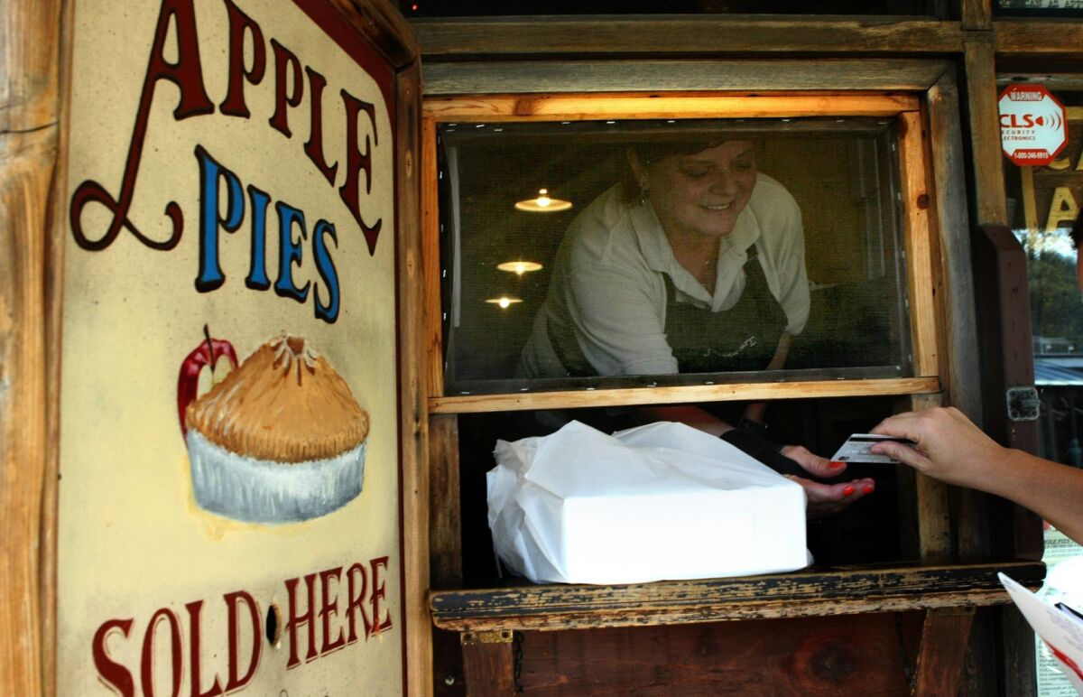 Diane Couture sells a pair of Apple Pumkin Pies to a customer at Julian Cafe. The pies are a specialty of the shop and are only available from October through the holiday season. — James Gregg