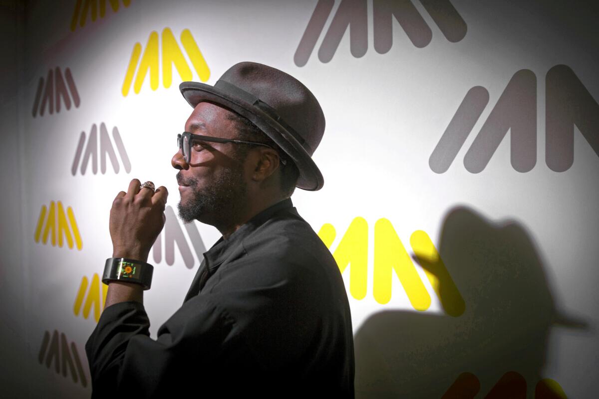 Hip-hop artist will.i.am of the Black Eyed Peas shows off his touch-screen-equipped $400 Puls wrist band, which makes and receives calls and texts, connects to social media and plays music.