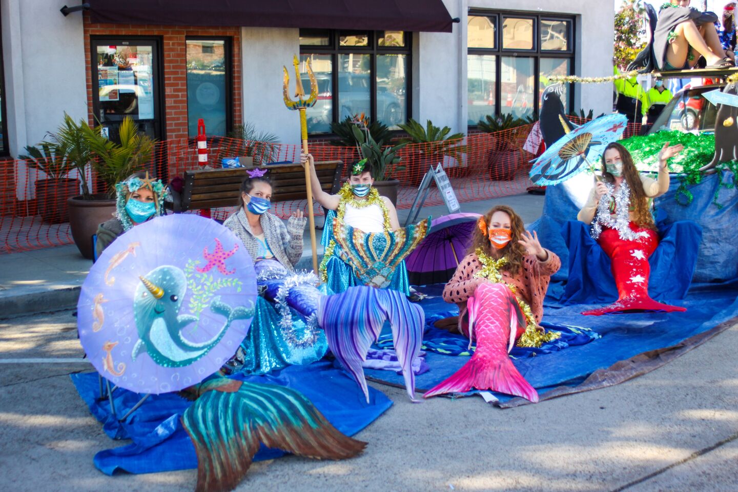 Mermaids from Erling Rohde Plumbing send holiday wishes to parade passersby.