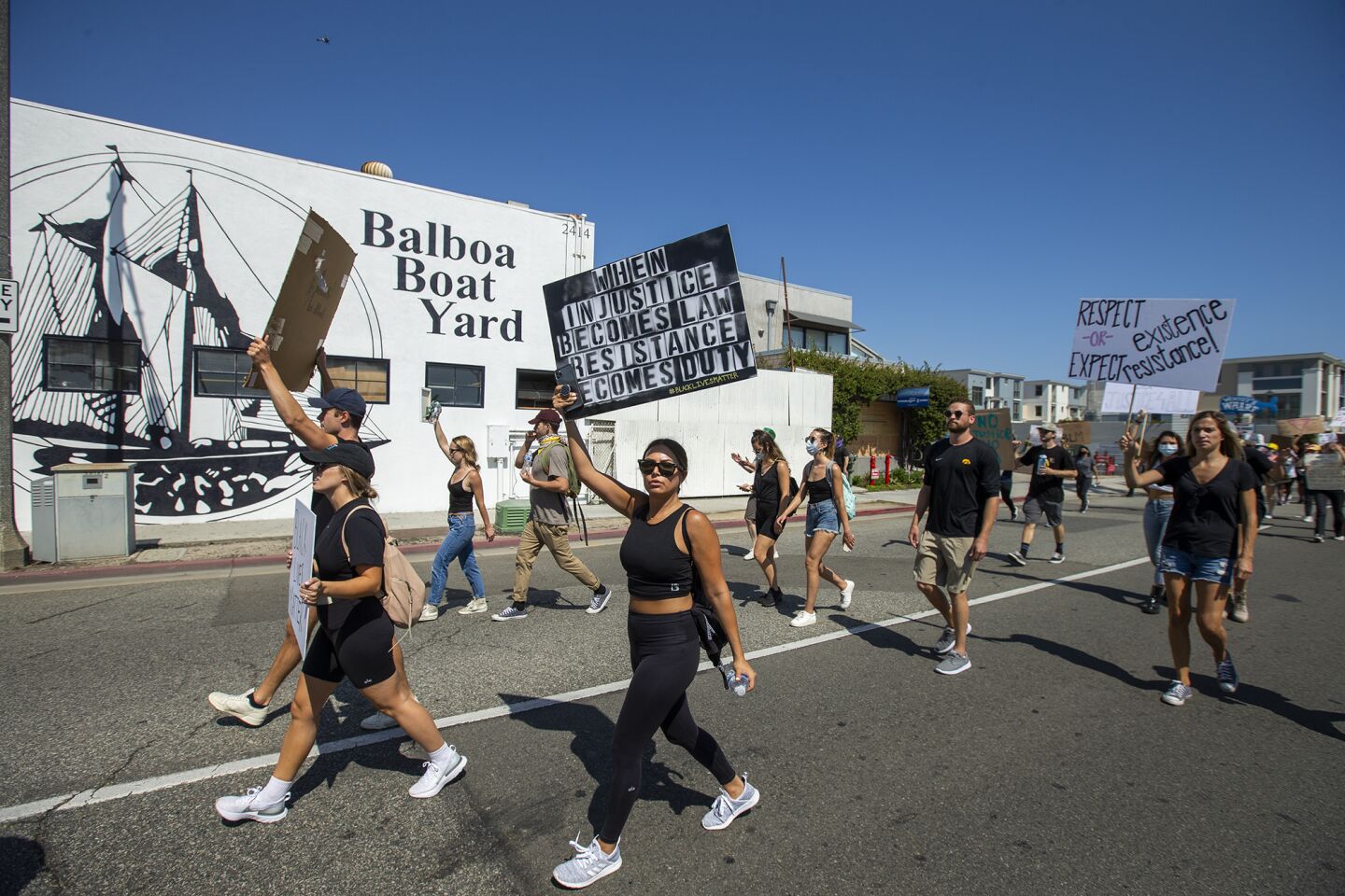 Demonstrators walk down Balboa Boulevard during a protest on Wednesday.
