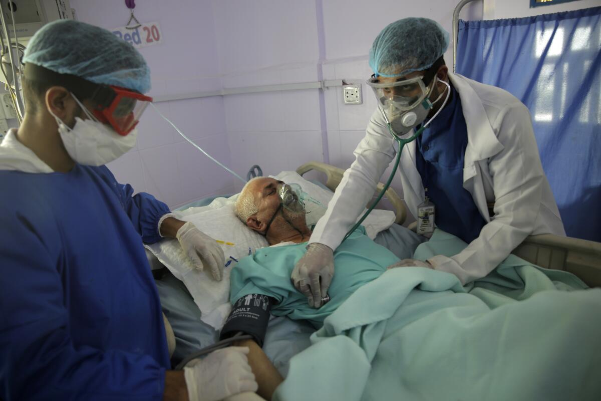 Medical workers tend to a COVID-19 patient in an intensive care unit at a hospital in Sana, Yemen. 