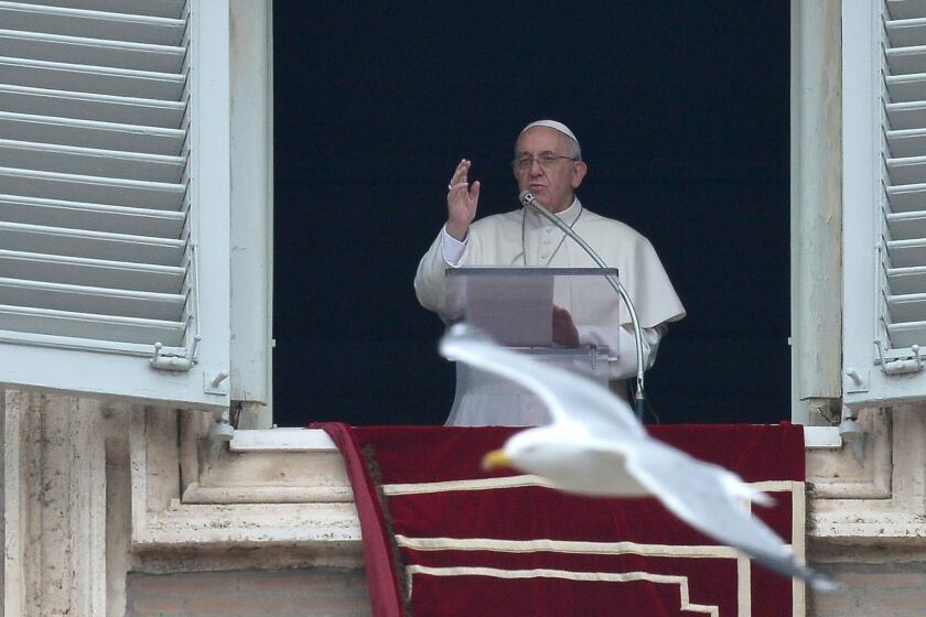Pope Francis addresses the crowd from his private apartments during his Sunday's Angelus prayer at St Peter's Square at the Vatican.