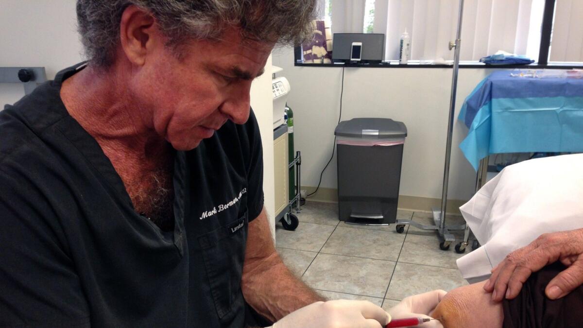 In this 2014 photo, Mark Berman of the Cell Surgical Network injects a patient at his practice in Beverly Hills with a solution that he says is rich in adult stem cells.