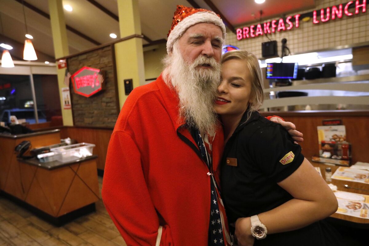 James Zyla gets a hug from waitress Kaylene Purcell, 17, at a Denny's restaurant in Kingman. Purcell helped Zyla get a gig at the Ramada hotel where he played his keyboard for free room and board.