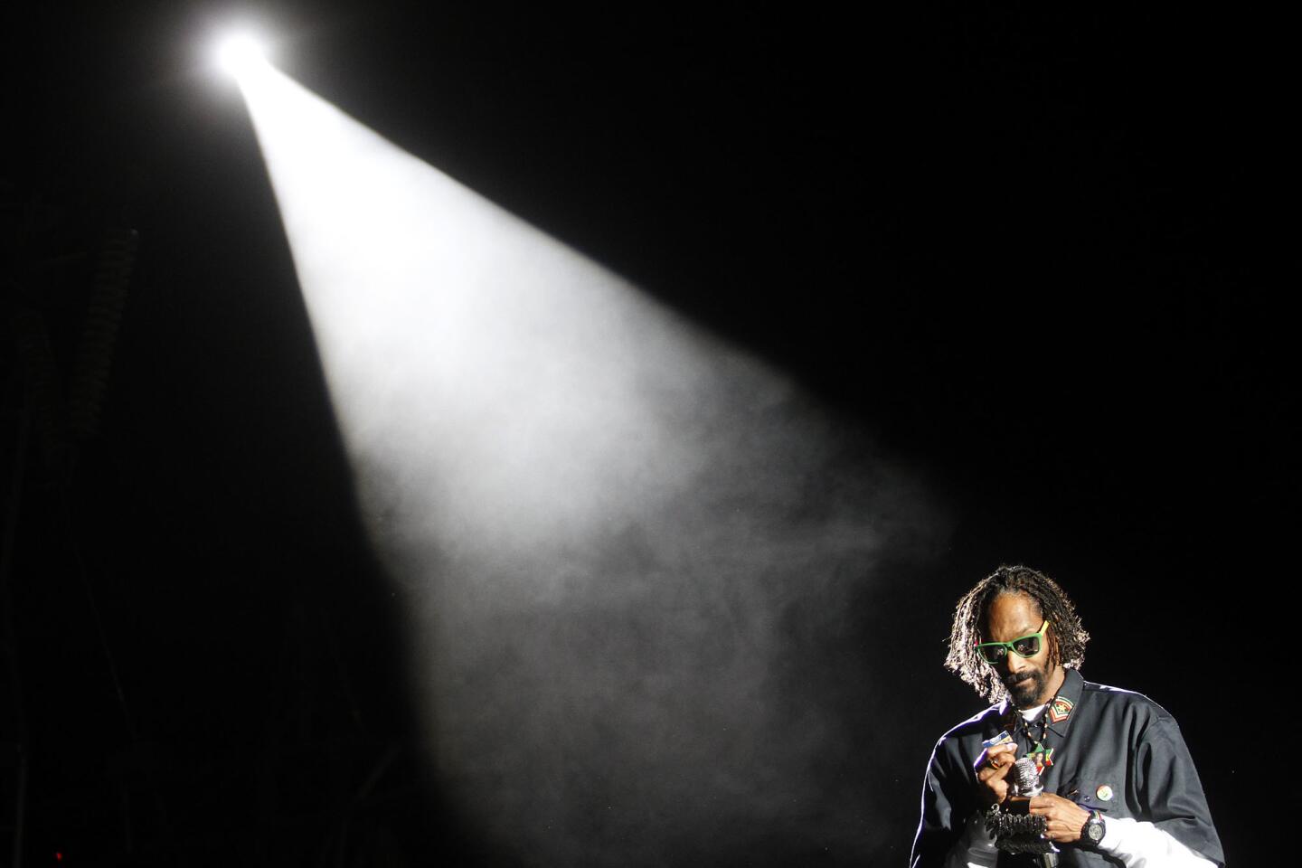 Snoop Dogg pauses to unwrap a blunt during his performance with Dr.Dre on the third night of the Coachella Music Festival, 2012.