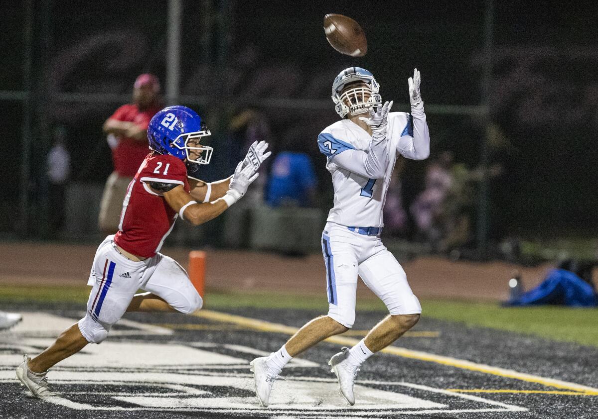 Corona del Mar's John Tipton catches a ball for a touchdown against Los Alamitos' Kevin Longstreet.  