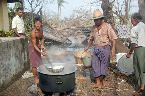 Cyclone affected families cook food from relief goods in the Konegyangone township in the outskirts of Yangon.