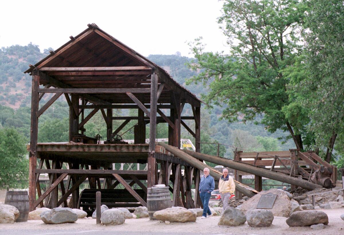 Tourists walk around a replica of Sutter's Mill