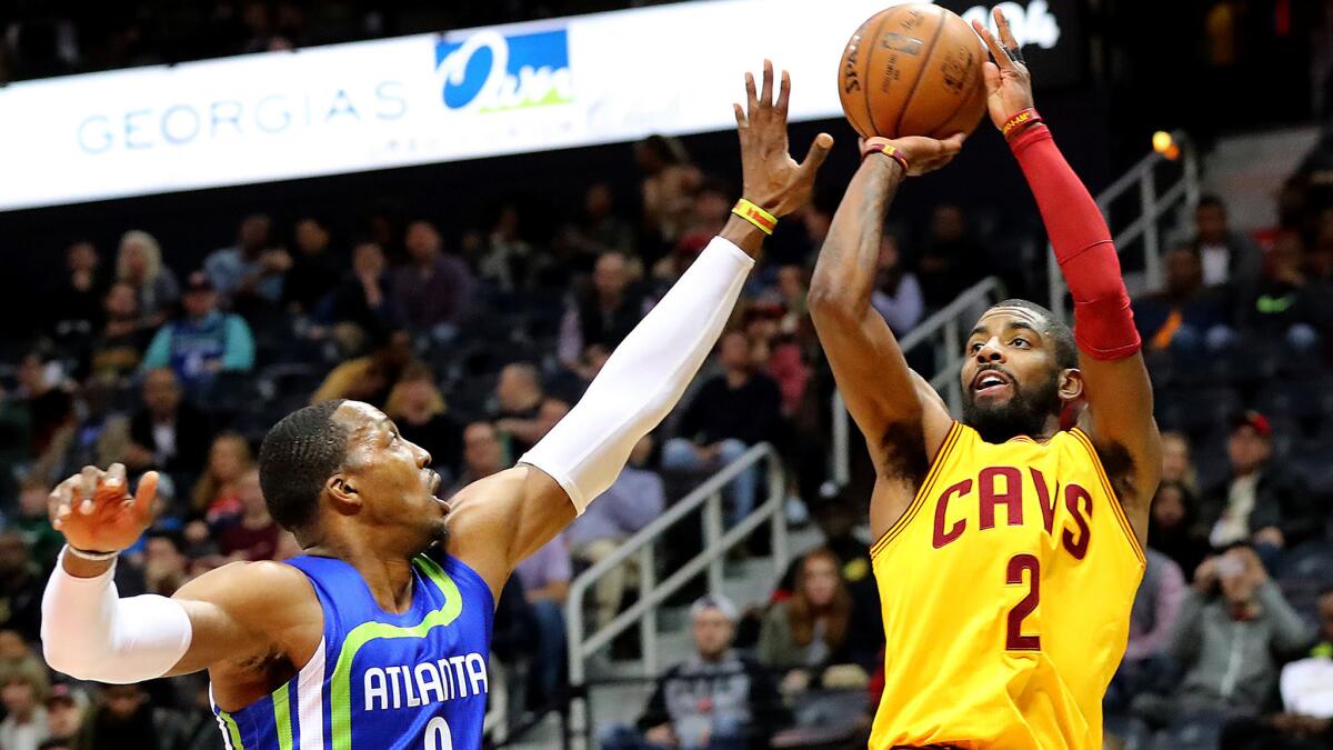 Cavaliers guard Kyrie Irving attempts a jump shot over Hawks center Dwight Howard during the first quarter Friday night.
