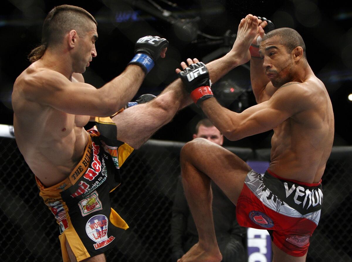 Jose Aldo, right, blocks a kick by Ricardo Lamas during the first round of their featherweight title fight at UFC 169 in Newark, N.J. Aldo went on to win by unanimous decision.