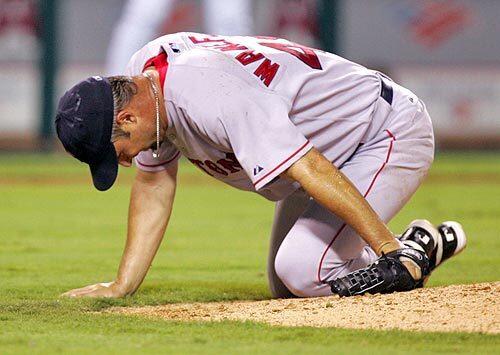 Boston Red Sox starting pitcher Tim Wakefield falls to his knees after being hit in the right ankle by Los Angeles Angels' Casey Kotchman.