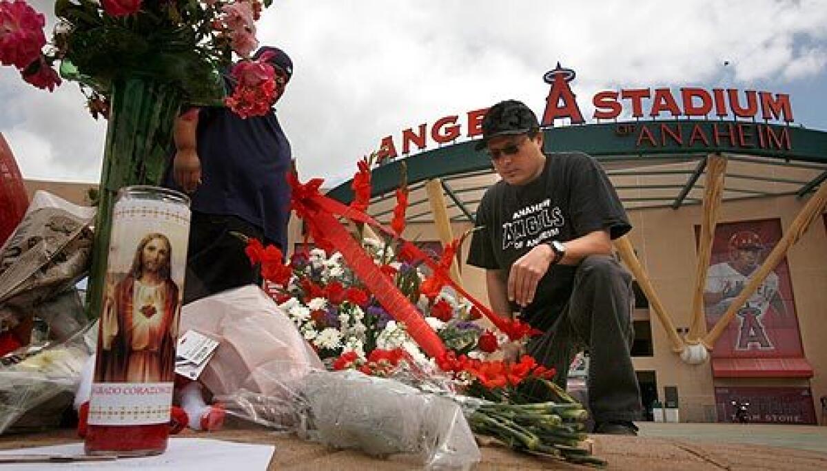 Robert Vargas, left, and Jason Lozano were among the many fans who stopped at Angel Stadium to leave flowers and remember pitcher Nick Adenhart. More photos >>>