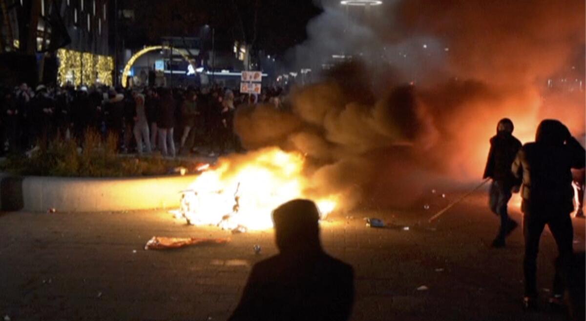 Demonstrators start a fire in the street to protest government restrictions due to the coronavirus pandemic