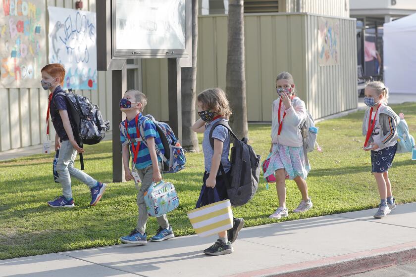 Kindergartners walk past "welcome back" posters as kids return for in-person learning at Top of the World elementary as part of the Laguna Beach Unified School District's hybrid learning model.
