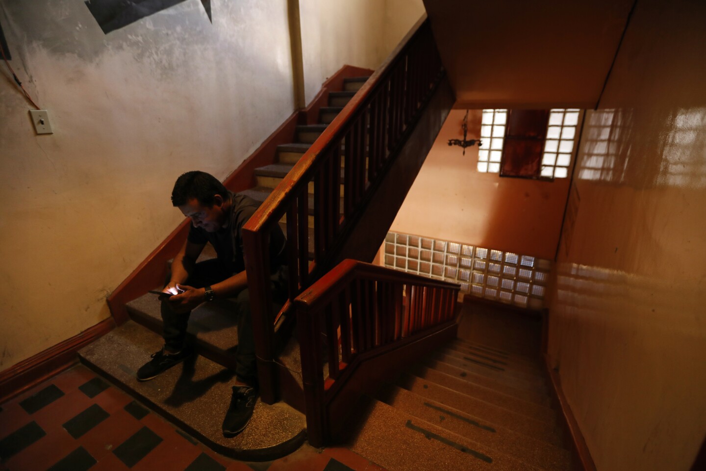 JUAREZ, MEXICO--JULY 3, 2019--(PLEASE DO NOT LIGHTEN HIS FACE- HE DOESN'T WANT HIS FACE USED, SO KEEP SHADOW) JUAREZ, MEXICO--JULY 3, 2019--A Cuban man sits in the stairwell to a hotel in Juarez, Mexico after he was released from immigration detention and returned to Mexico. He are a group of Cuban men are sharing a room in a cheap hotel in Juarez, Mexico until they decide their next step. It could be six months or more before their next immigration hearing. Thousands of Cubans have left their home and are waiting in Juarez, Mexico to come to the United States to seek asylum. Recently the U.S. have been sending the Cubans back to wait in Mexico. (Carolyn Cole/Los Angeles Times)Thousands of Cubans have left their home and are waiting in Juarez, Mexico to come to the United States to seek asylum. Recently the U.S. have been sending the Cubans back to wait in Mexico. (Carolyn Cole/Los Angeles Times)