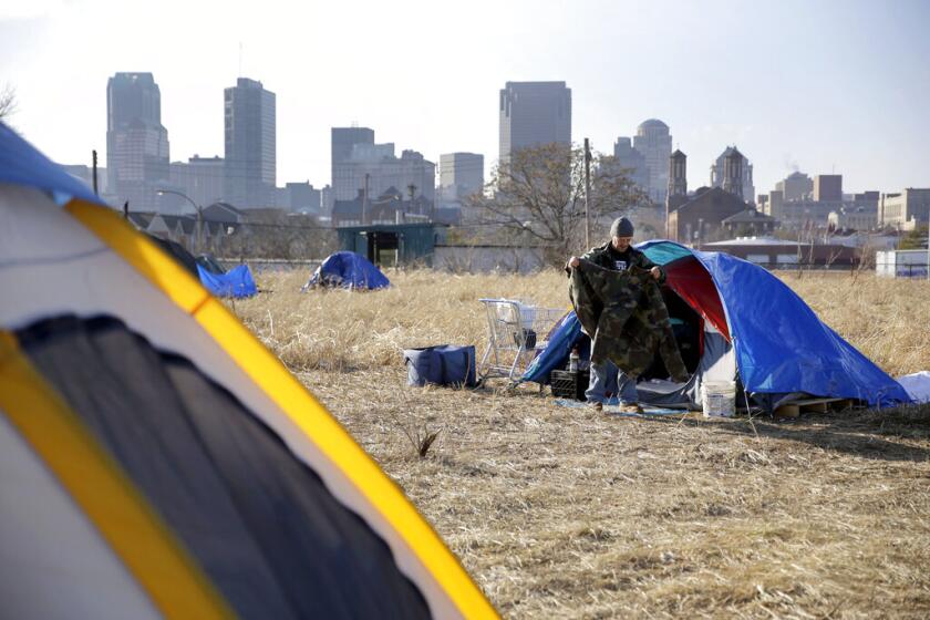 A man cleans out his tent at a homeless encampment near downtown St. Louis in 2015.
