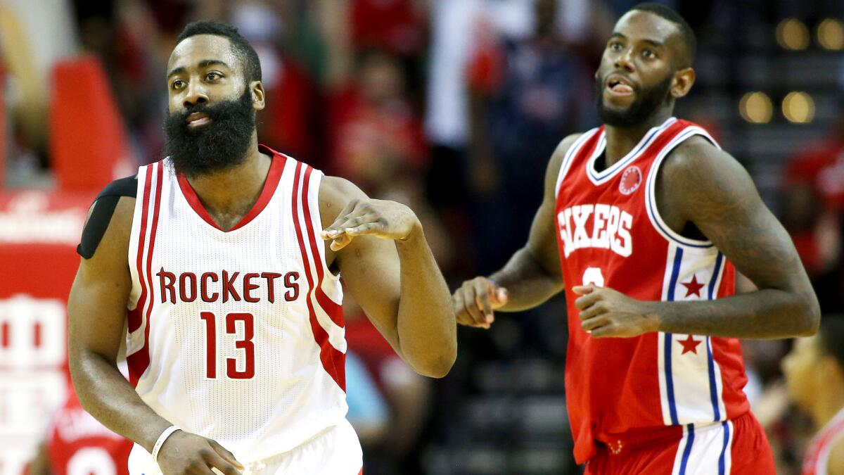 Rockets guard James Harden celebrates after making a three-point shot against 76ers forward JaKarr Sampson on Friday night.