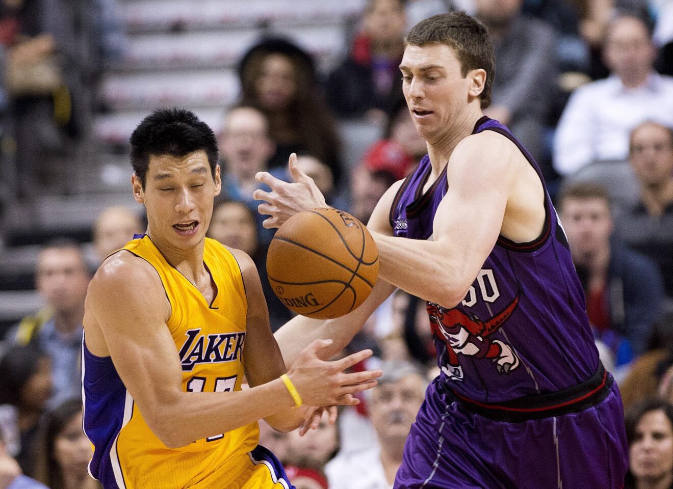 Lakers guard Jeremy Lin and Raptors forward Tyler Hansbrough try to get a grasp on a loose ball in the second half.