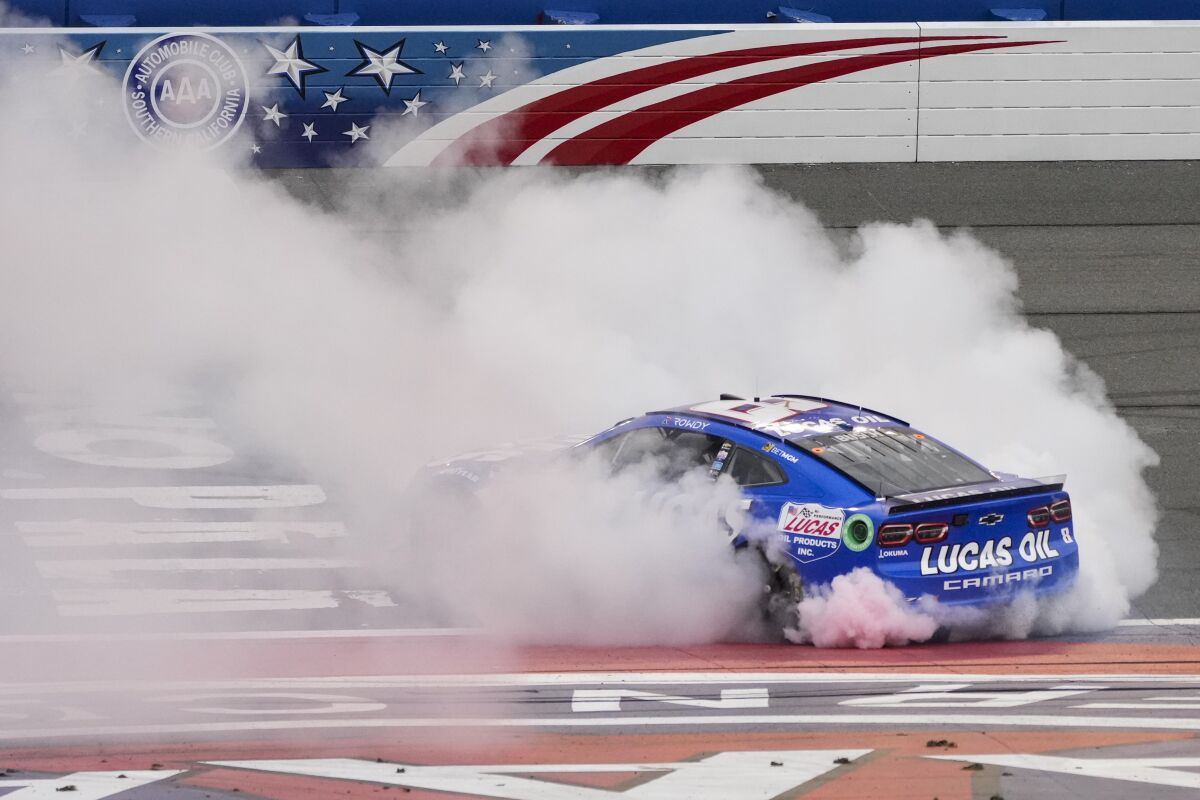 Kyle Busch performs a burnout near the start/finish line after winning at Fontana on Sunday.