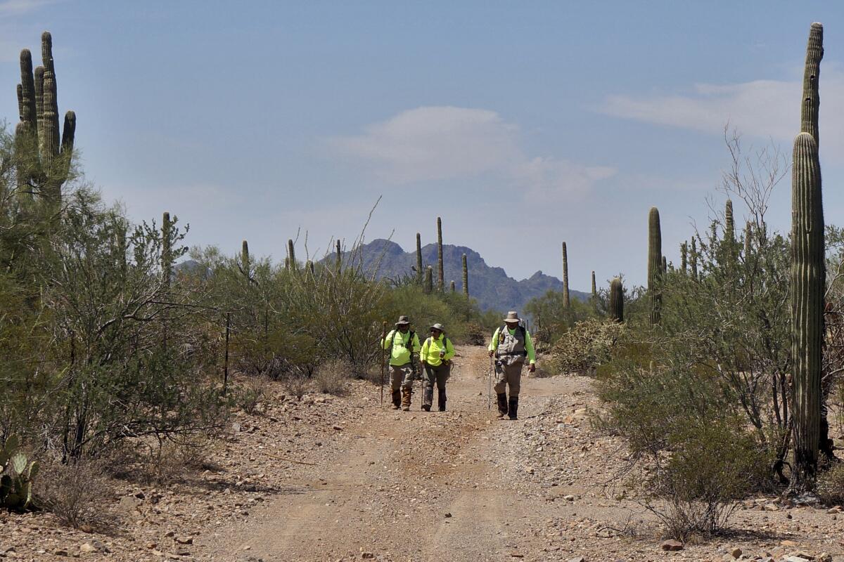 Pastor Óscar Andrade walks with volunteers in the Ironwood Forest National Monument.