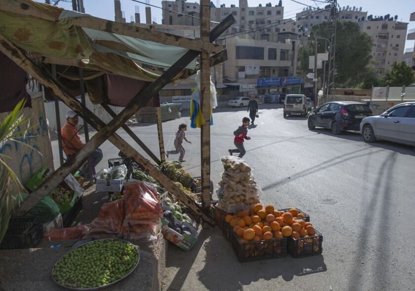 A Palestinian vendor displays his vegetables in the street as the main vegetable market remains closed because of the coronavirus in the West Bank village of Kufr Aqab.