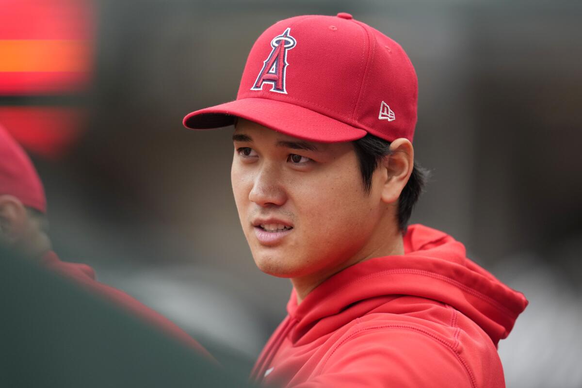 Los Angeles Angels' Shohei Ohtani sits in the dugout during a baseball game.
