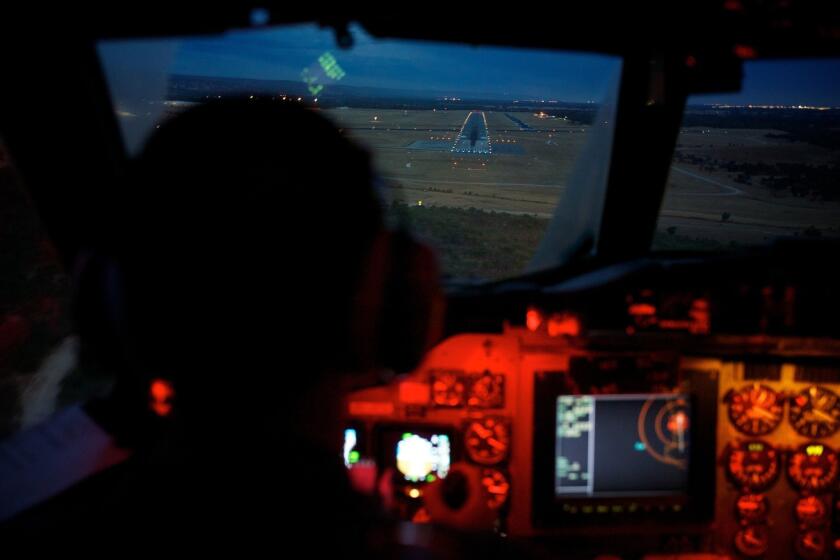 Marc Smith, copilot of an Australian air force AP-3C Orion, approaches the Pearce air base in Perth, Australia. The air and sea search for Malaysia Airlines Flight 370 was suspended Tuesday because of gale-force winds, heavy rain and big waves, the Australian Maritime Safety Authority said.