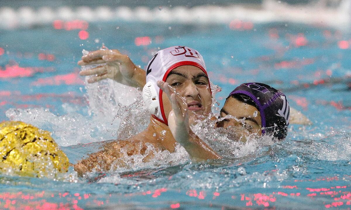 Burroughs' Vahagan Sahakyan holds the ball back as Hoover's Samvel Manukyan puts a lot of defensive pressure on him to free the ball in the Pacific League preliminary boys' water polo tournament at Arcadia High School on Tuesday, October 29, 2019. Hoover won the game advancing to the finals.