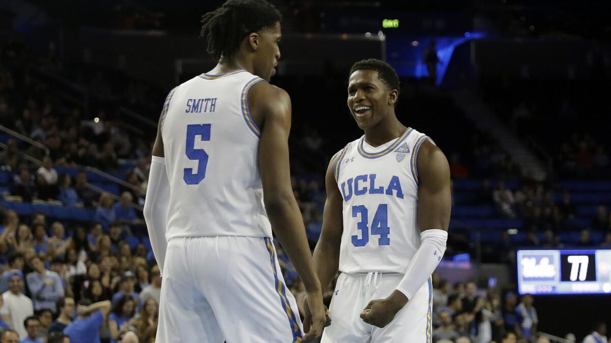 UCLA guard Chris Smith celebrates with teammate David Singleton (34) after scoring against St. Francis during the second half of their game Friday.