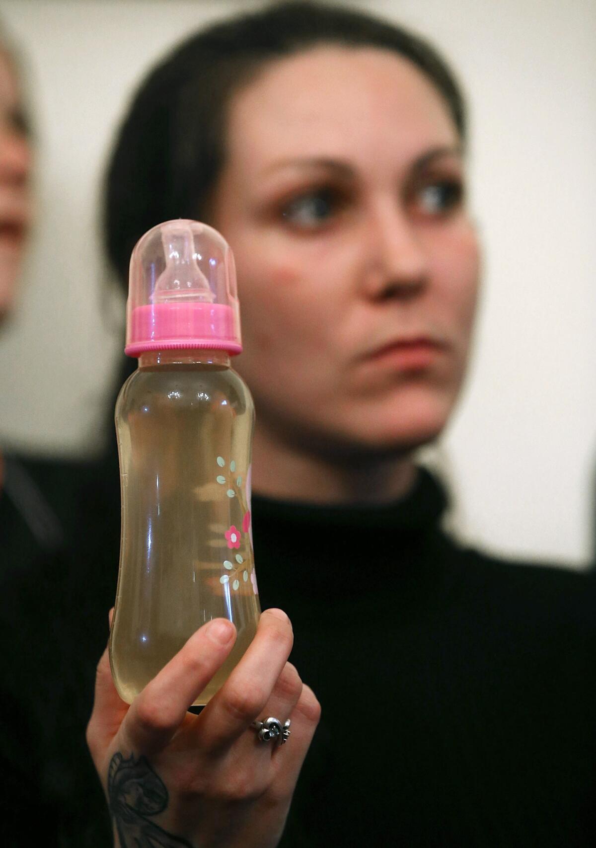 Flint, Mich. resident Jessica Owens holds a baby bottle filled with contamined water during a news conference after attending a House Oversight and Government Reform Committee hearing on Feb. 3, 2016.
