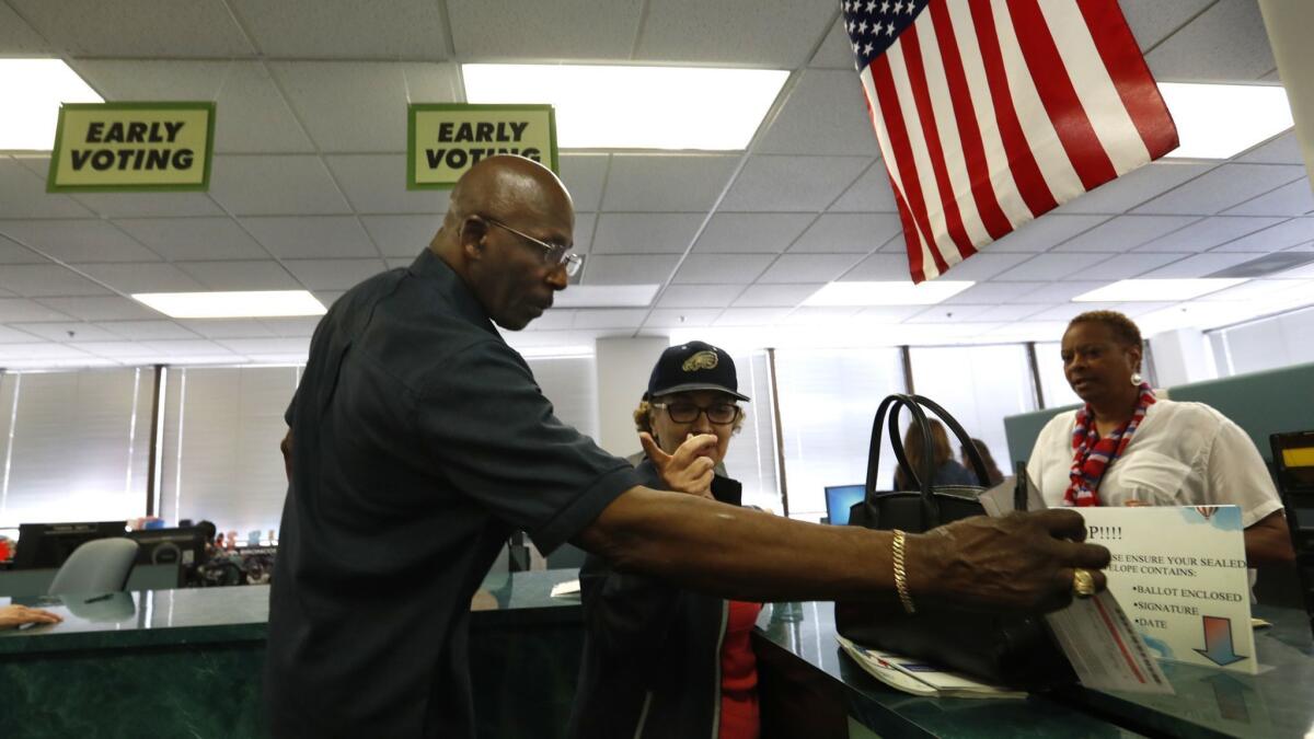 Billy Brown of Los Angeles drops his ballot in a box earlier this year at the Los Angeles County registrar-recorder's office in Norwalk.