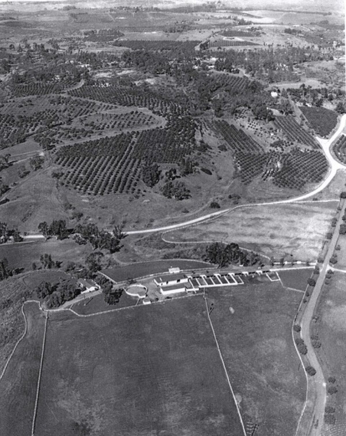 An aerial of the Osuna adobe in 1928, adjacent to the Loomis Stables. Via De La Valle and Via De Santa Fe are visible.