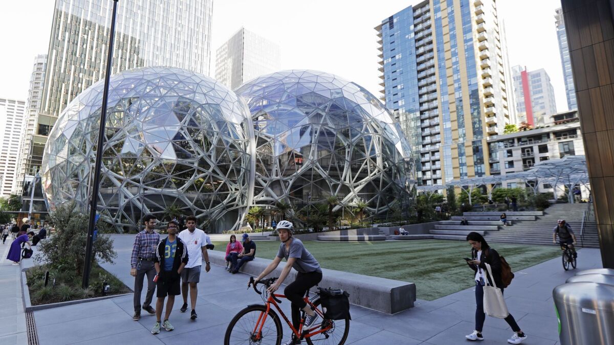 Pedestrians and cyclists pass the Amazon Spheres in Seattle on May 7.