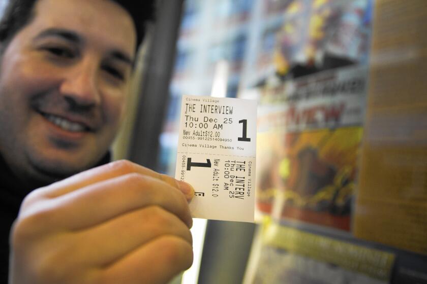 Derek Karpel holds his ticket to a screening of "The Interview" at Cinema Village movie theater in New York on Christmas Day.
